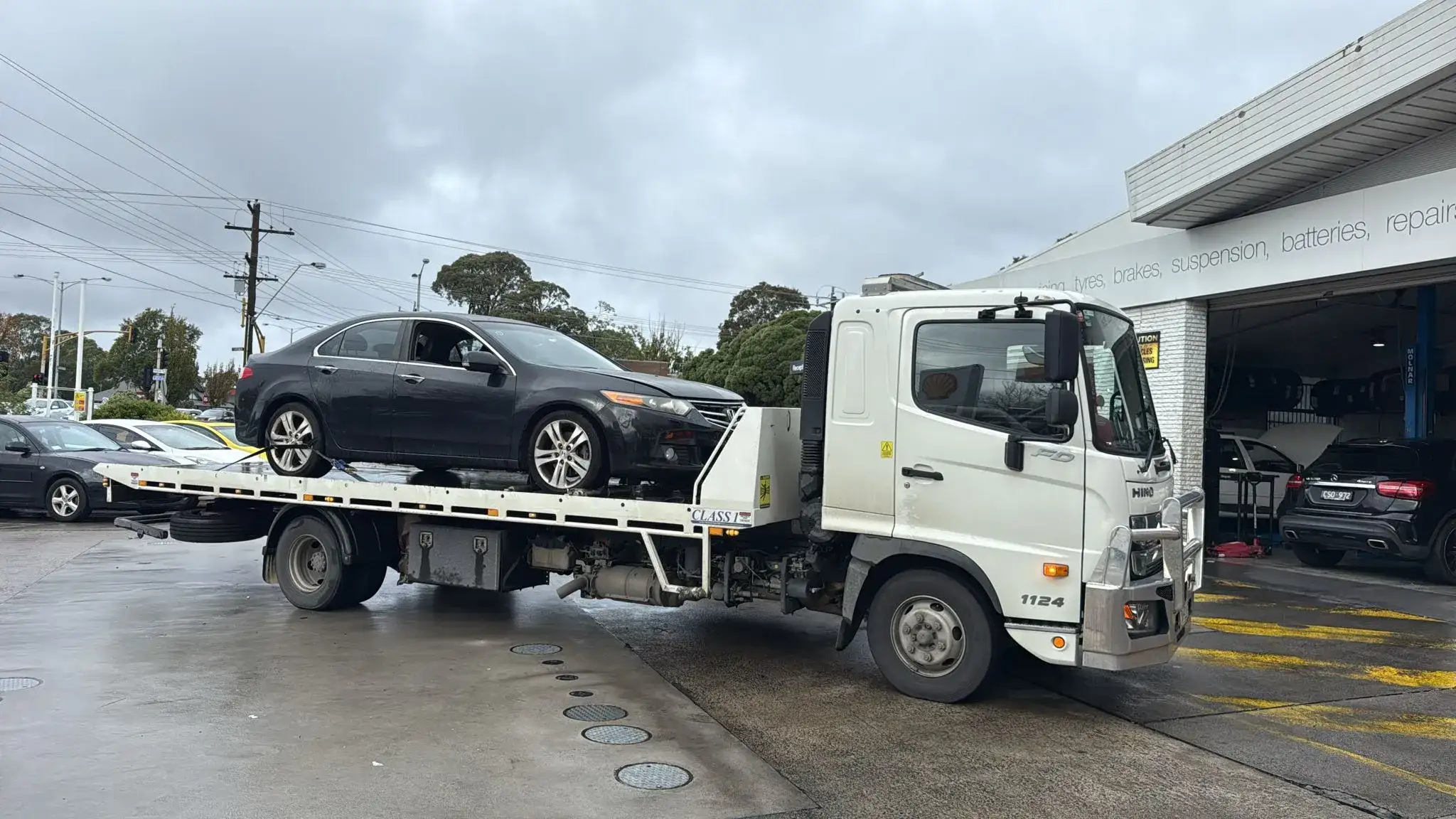 Black car being transported by a car removal truck in Melbourne